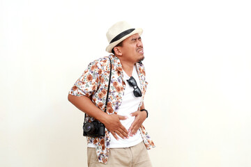 Painful asian adult man tourist standing while holding his stomach. Suffering from stomach ache....