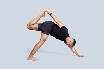 Calm strong millennial caucasian man with beard in sportswear practice yoga, stretching hand