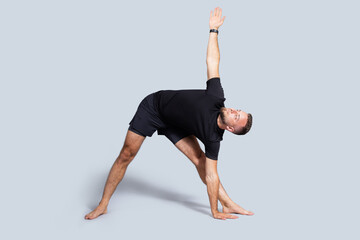 Calm handsome millennial european guy with beard in sportswear practice yoga, breath exercises,...