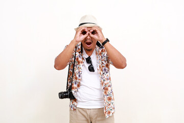 Asian man traveler standing while using his hands for binoculars looking at camera. Isolated on white background with copyspace