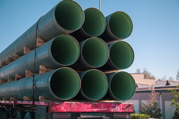 Large pipes are carried in the back of the cart