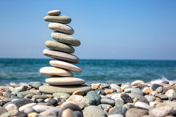 Fototapeta na wymiar Pyramid of stones on the seashore. balance and harmony of life and rest
