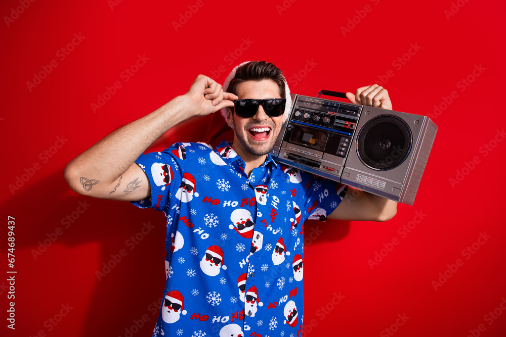 Sticker Photo of happy new year nostalgy party young guy cassette player boombox wear sunglasses with blue shirt isolated on red color background