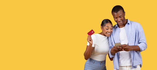 African american couple with credit card and phone on yellow background
