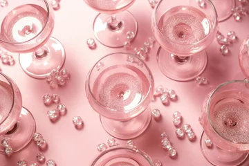 Foto op Plexiglas Many glasses of rose wine or cocktail on pink background with glitter and tinsel. Summer beach cocktail party with alcohol beverage. Valentine's, women's day, birthday or wedding concept  © ratatosk