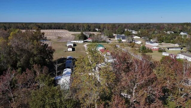 A rising aerial view of a small North Carolina residential neighborhood revealing a trailer park.  	