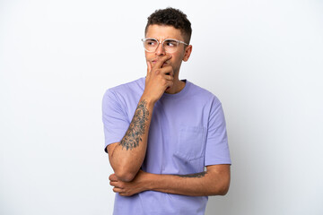 Young caucasian Brazilian man isolated on white background having doubts and with confuse face expression