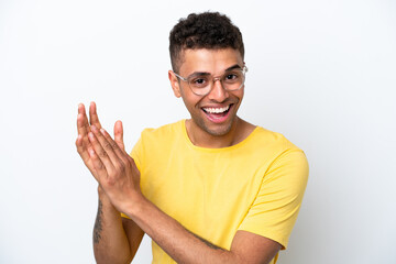 Young Brazilian man isolated on white background With glasses and applauding
