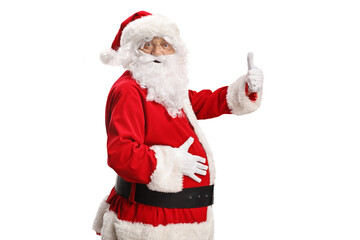Side shot of Santa claus holding his belly and gesturing thumbs up