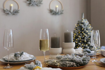 table set for dinner in the apartment decorated for the New Year and Christmas
