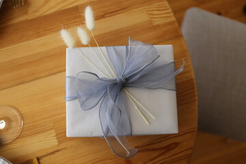 gift box with a gray bow and spikelets on the table