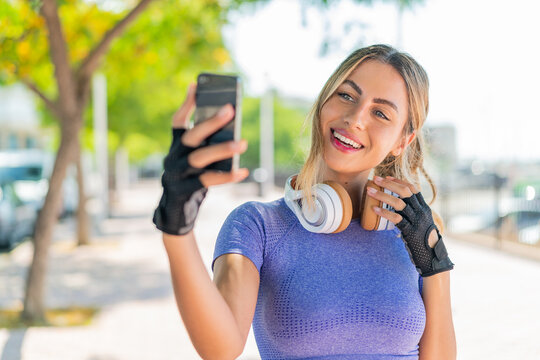 Young pretty sport woman at outdoors making a selfie
