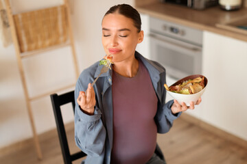 Pregnant woman enjoying a healthy meal, savoring every bite