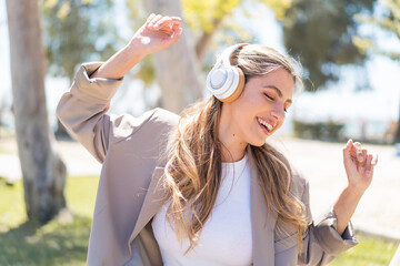 Pretty blonde Uruguayan woman listening music and dancing