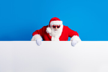 Photo portrait of mature pensioner man look down amazed banner wear trendy santa claus costume coat isolated on blue color background