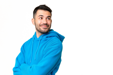 Young handsome caucasian man over isolated chroma key background with arms crossed and happy