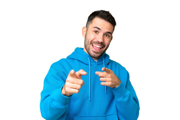 Young handsome caucasian man over isolated chroma key background surprised and pointing front