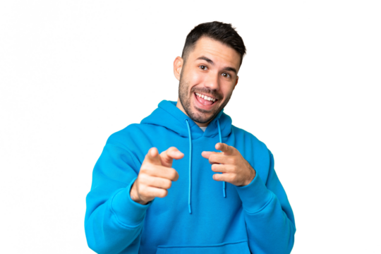 Young handsome caucasian man over isolated chroma key background surprised and pointing front