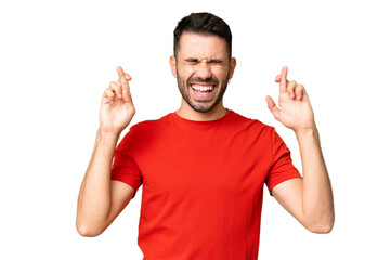 Fototapeta premium Young handsome caucasian man over isolated chroma key background with fingers crossing