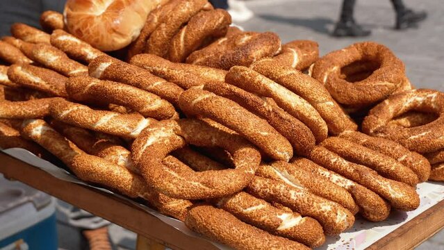 Heap of Turkish simits. Fresh simit on street. Turkish sesame bagels. Popular Turkish street food simit. Simit background, side view