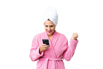 Middle age caucasian woman in a bathrobe over isolated background surprised and sending a message