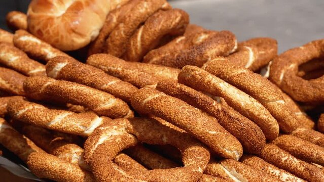 Heap of Turkish simits. Fresh simit on street. Turkish sesame bagels. Popular Turkish street food simit. Simit background, side view