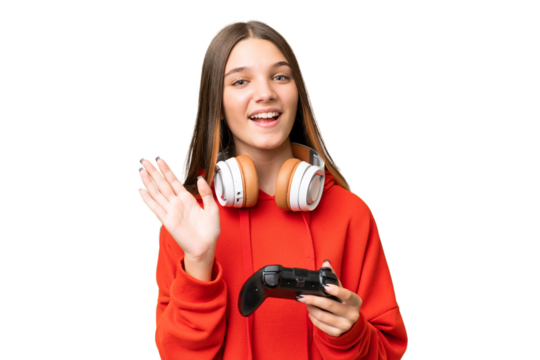 Teenager caucasian girl playing with a video game controller over isolated background saluting with hand with happy expression