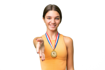 Teenager caucasian girl with medals over isolated background shaking hands for closing a good deal