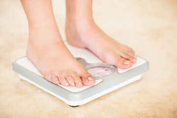 Woman, weight loss and feet on scale for measurement, goal and control diet for health and...