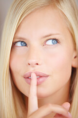 Woman, silence and finger on lips for idea with sign, secret deal or thinking for skincare by...