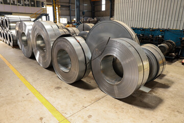 A wide view of industrial machines manufacturing metal sheets in a warehouse - obrazy, fototapety, plakaty