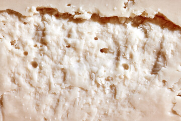Texture of delicious, organic, natural hard cheese. Sliced. Wallpaper, background. Concept of food, taste, art of organic products, healthy and natural food.