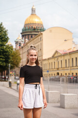 A young girl on a tourist visit to St. Petersburg against the background of St. Isaac's Cathedral
