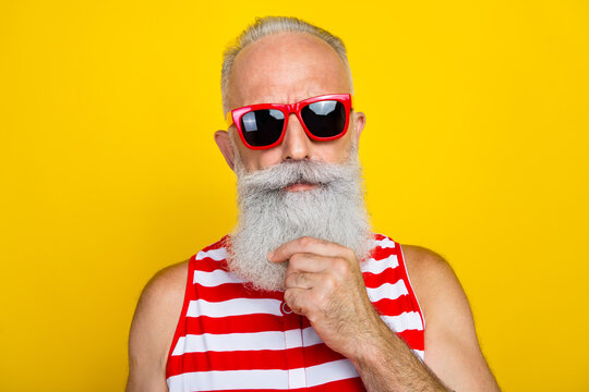 Photo of smart clever senior man wear red striped swimsuit dark glasses hand arm chin isolated yellow color background