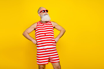 Photo of cheerful dreamy senior man wear red striped swimsuit looking empty space isolated yellow...