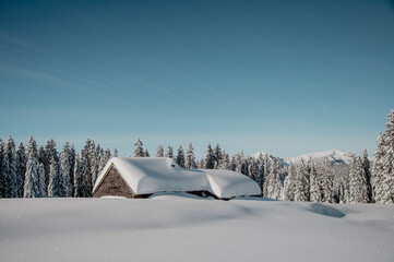 A mountain wooden hut covered in snow in Swiss Alps