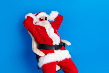 Photo portrait of mature pensioner man hands behind head sleepy dressed stylish santa claus costume coat isolated on blue color background