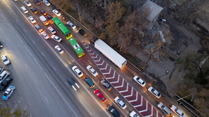 A busy intersection with a lot of cars, buses and trucks. Aerial view from the drone on the night...