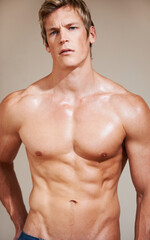 Fototapeta premium Man, portrait and muscular with abs, workout and shirtless for body, strong and model in studio background. Fit, muscle and athlete for six pack, topless and bodybuilder for health, exercise and face