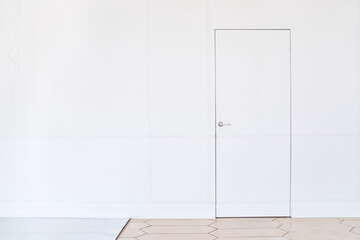 Wooden white door on a light background. Creative idea of a closed door, an entrance doorway...