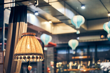 Vintage floor lamp with yellow light on the background of hanging lamps in the restaurant in the...
