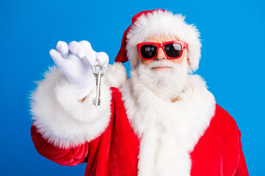 Photo portrait of mature pensioner man point show house key dressed stylish santa claus costume coat isolated on blue color background