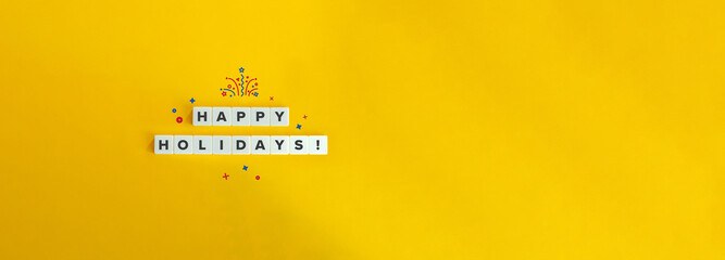 Happy Holidays Phrase on Block Letter Tiles on Bright Orange Yellow Background with Copy Space.