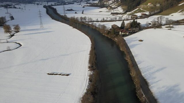 Aerial view of a snow covered field and the Ziller river surrounded by mountains, Fuegen Tyrol, Austria.