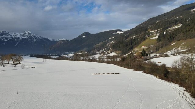 Aerial view of the snow covered fields in Zillertal with mountains and the Ziller river, Fuegen, Tyrol, Austria.