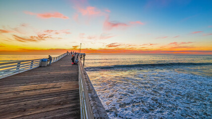Fototapeta na wymiar Wooden pier in Pacific Beach at sunset