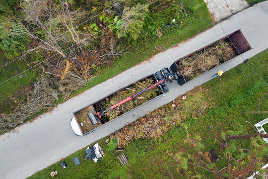 Special Aftermath Recovery Dump Truck Picking Up Vegetation Debris From Suburban Streets After Hurricane Ian Swept Through Florida. Dealing With Consequences Of Natural Disaster