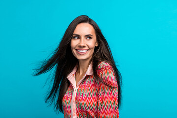 Fototapeta premium Portrait photo of beautiful model girl hair flying haircare product ads ad adv wearing printed blouse isolated teal blue color background