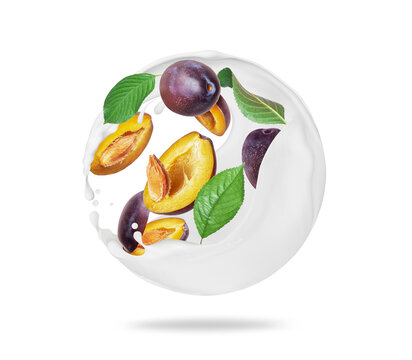 Whole and sliced plums in spherical milk splashes on a white background