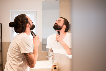 Junger Mann rasiert sich den Bart. Bartschneider. Männerpflege